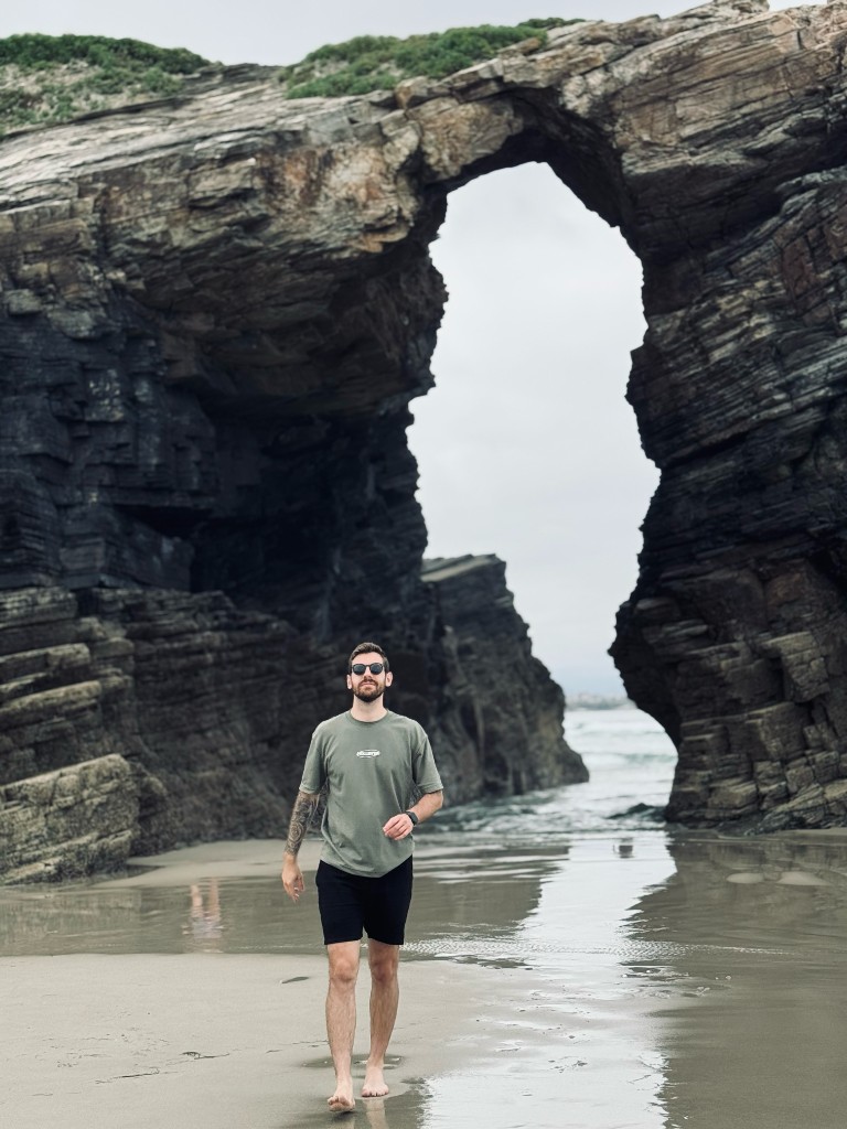 Viktor at the beach by a rock arch